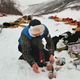 Arnt Ola Skjerve opens some meat cans for his dogs at a checkpoint.